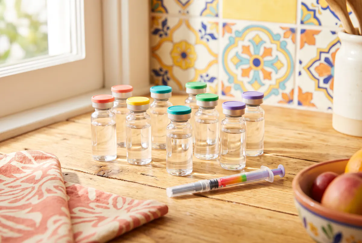 Small vials with caps in many colours grouped on a sunny kitchen counter